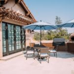 Outdoor kitchen and seating area with two outdoor Sonance Mariner 66 speakers