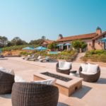 Outdoor sitting area by the pool with the outdoor Sonance speakers barely visible thanks to discreet design and placement